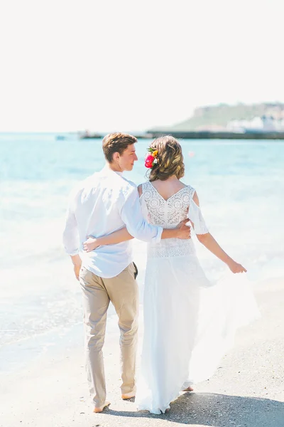 Newly-married couple making a walk along the beach — Stock Photo, Image