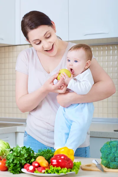 Jeune mère nourrissant bébé pomme. Une famille heureuse . — Photo