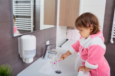 Küçük kız bathroo içinde diş fırçalama