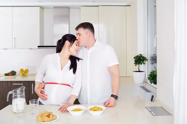 Casal com mulher grávida relaxando na cozinha juntos . — Fotografia de Stock