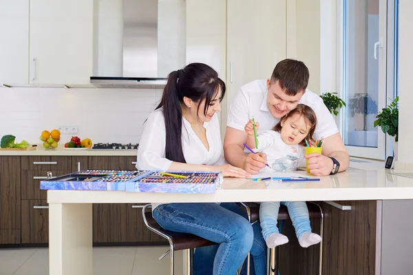 Smiling family drawing together in kitchen at home — Stock Photo, Image