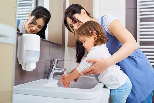 Enfant se lave les mains avec maman dans la salle de bain . — Photo