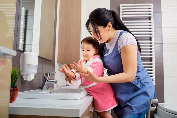 Mutter und Tochter waschen sich im Badezimmer die Hände. Pflege und — Stockfoto