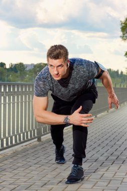 Gün batımında yalnız Park'ta koşan genç adam.