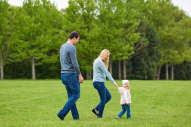 Mutlu genç aile yeşil doğada birlikte dışarıda.