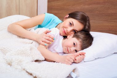 Güzel kadın ve oğlu yatakta kucakladı.