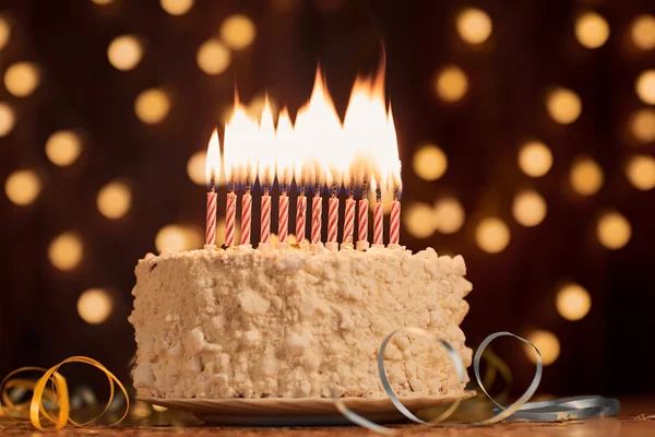 Cake shot on a bokeh background with candles. — Stock Photo, Image