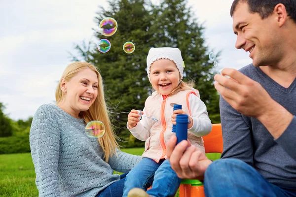 Family playing with bubbles outdoors. — Stock Photo, Image