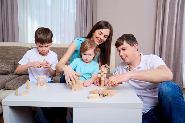 Família na mesa jogando jogos de tabuleiro . — Fotografia de Stock