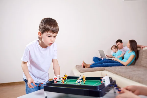 Αγόρι παίζει στο σπίτι σε επιτραπέζια παιχνίδια. Οι γονείς να χαλαρώσουν — Φωτογραφία Αρχείου
