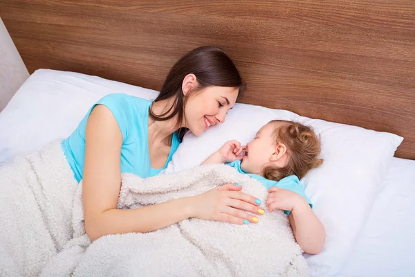 Familia feliz con niños en la cama. Madre e hija sonriendo i — Foto de Stock