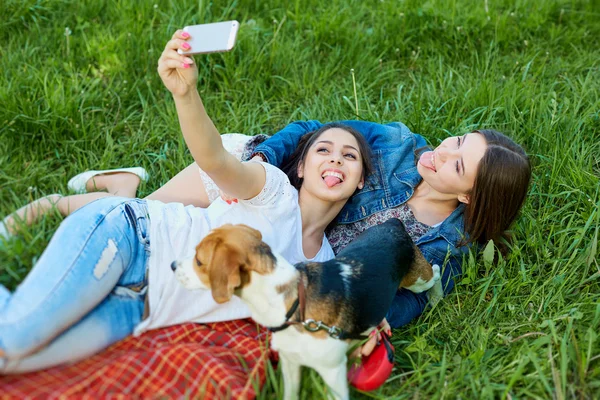 Meninas felizes com seu cão beagle sentado no parque verde e maki — Fotografia de Stock