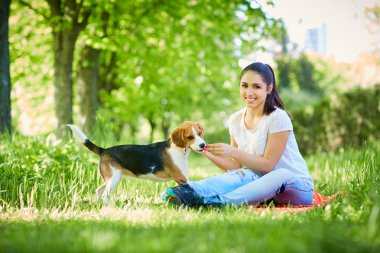 Parkta köpeğiyle birlikte genç bir kadının portresi. 