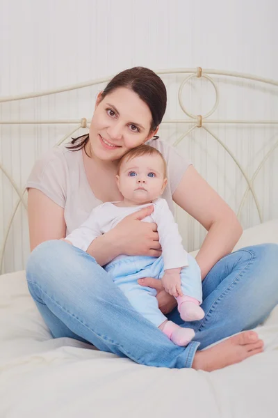 Portret van een moeder en de baby in de slaapkamer. — Stockfoto