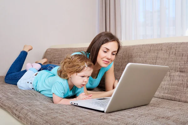 Mother and her daughter looking at laptop at home — Stock Photo, Image