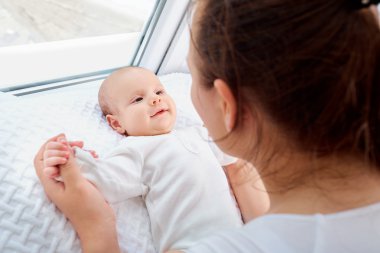 Gülümseyen annesine bakıyor bebek.