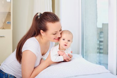 Pencerenin yanında Holding tatlı bebeğim anne.