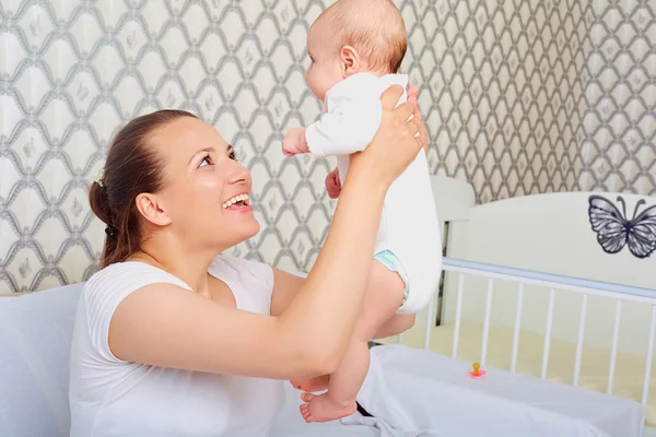 Happy mother with a baby in her arms. Up. — Stock Photo, Image