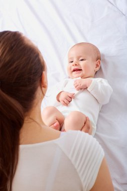 Odasındaki yatakta emekleyen bir bebeğin portresi.