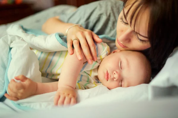 Bebé durmiendo en la cama con madre. Cuidado. . — Foto de Stock