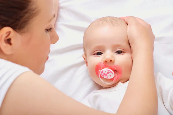 My mother takes care of the baby, hugging his head on his hand. — Stock Photo, Image