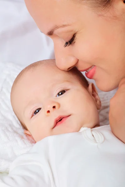 Mother hugging with her baby in the bedroom.Looking in the camer Stock Photo