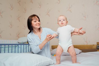 Annem bebeği yatağa yatırmayı öğrenir. Mutlu ve gülümse. Mutlu fami