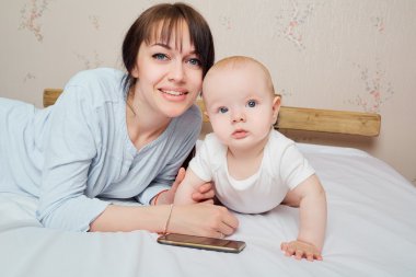 Küçük çocuk, sağlıklı bir bebek ve anne tutuyor. Anne ve bebek