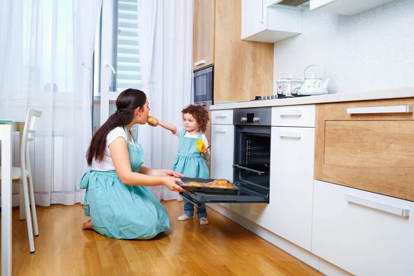 Familia feliz en la cocina. Feliz mamá enseña a su hija a cocinar — Foto de Stock