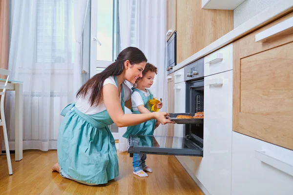 Bonne famille dans la cuisine. Maman heureuse enseigne à sa fille à cuisiner — Photo