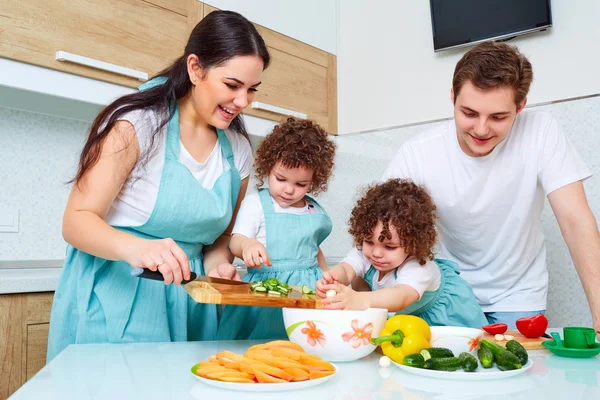 Jumelles fille avec ses parents dans la cuisine manger des petits pains. Un heureux — Photo