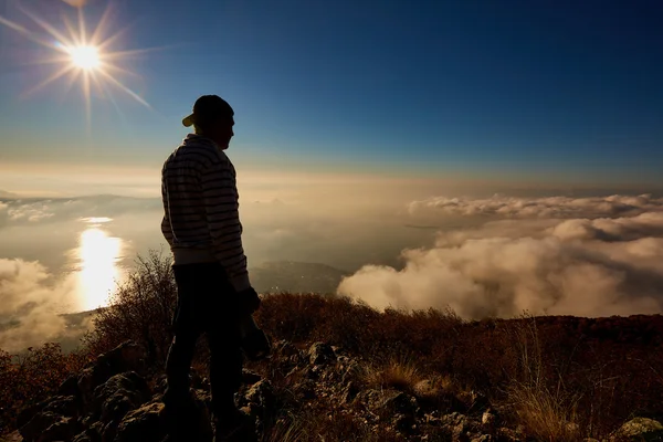 Silueta fotografa s kamerou v horách za svítání — Stock fotografie