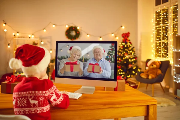 Little boy video calling grandparents who have prepared Christmas presents for him — Stock Photo, Image