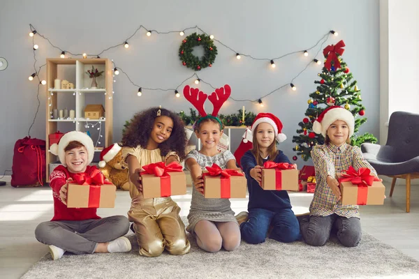 Farklı milletlerden çocuklar sıraya girip önlerinde Noel hediyelerini tutarlar.. — Stok fotoğraf