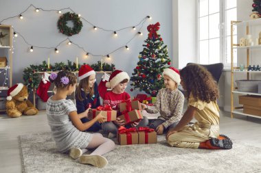 Bir grup mutlu melez çocuk evde Noel partisi veriyor ve hediyeler veriyor.