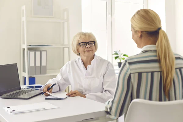 Médecin principal prescrivant un traitement pour la jeune femme lors du check-up dans une clinique moderne — Photo