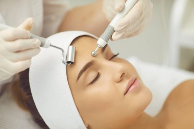 Kadınlar için mikro akım tedavisini uygulayan kozmetologların elleri