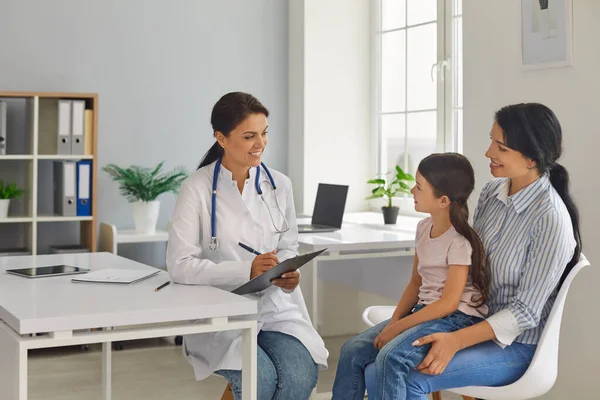 Madre e hija en el consultorio de médicos. El pediatra prescribe tratamiento al paciente. Médico. —  Fotos de Stock