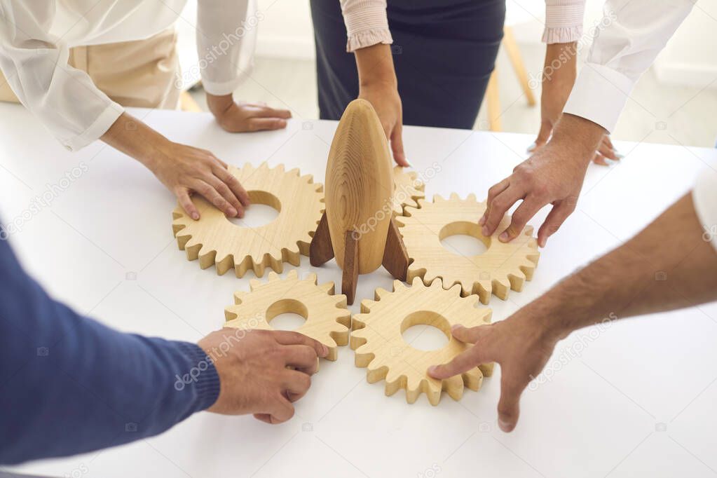 Close up of peoples hands put together wooden figures. Training for businessmen.