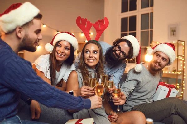 Sonriendo jóvenes amigos tintineando copas de champán y pronunciando brindis de Feliz Año Nuevo — Foto de Stock