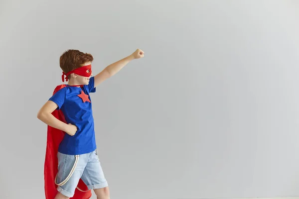 Маленький усміхнений хлопчик в костюмі супергероя з червоним плащем і окулярами готовий до пригод . — стокове фото
