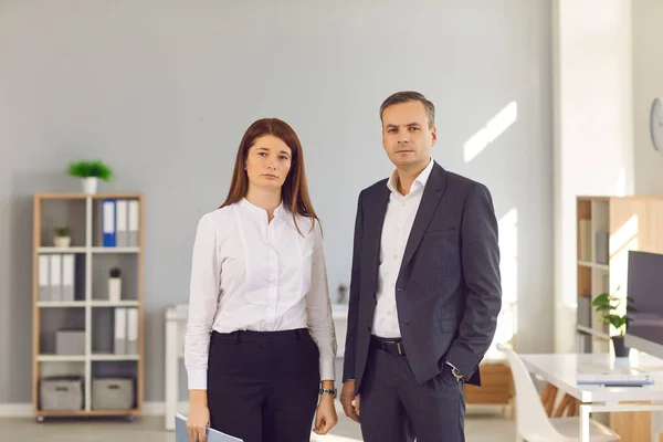 Retrato de gente de negocios confiada de pie en la oficina y mirando a la cámara —  Fotos de Stock