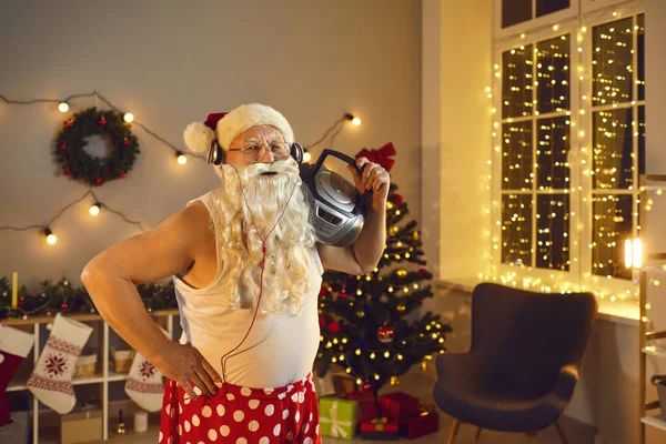Zabawny dziadek z brodą Mikołaja, słuchawki i boombox zabawy w Boże Narodzenie w domu — Zdjęcie stockowe