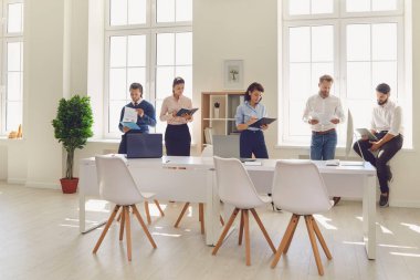 Ciddi şirket çalışanları şirket toplantısından önce mali raporlarını gözden geçiriyorlar.