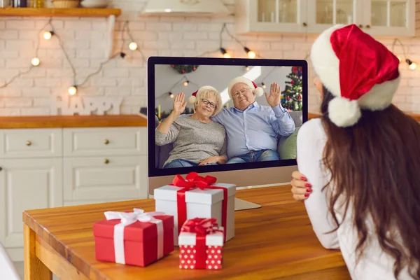 Young woman video calling her elderly parents on Christmas holidays in lockdown