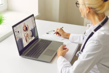 Bilgisayardaki video görüşmesi sırasında hasta kadın hastaların şikayetlerini dinleyen kadın doktor.