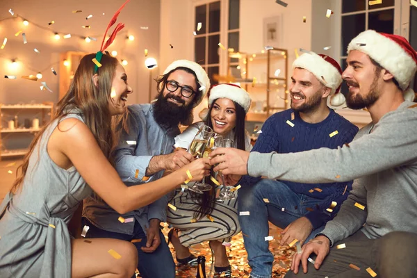 Group of people with glasses of champagne in their hands together celebrate the New Year.