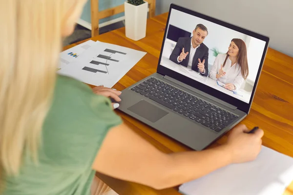 Egy nő ül az asztalnál, üzleti webináriumot néz, vagy virtuális találkozója van munkatársakkal — Stock Fotó