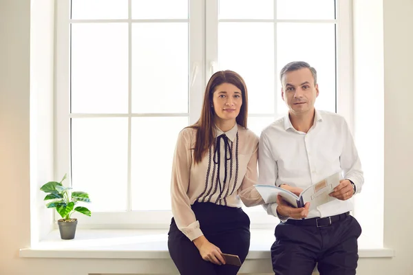 Dos personas socios de negocios mirando la cámara interrumpida durante su discusión — Foto de Stock