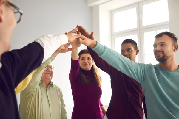 Tým šťastných různorodých lidí se drží za ruce při týmové činnosti nebo při klubovém setkání — Stock fotografie